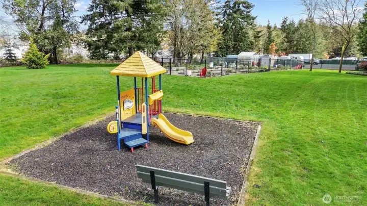 Playground with community garden and RV parking shown in the distance.
