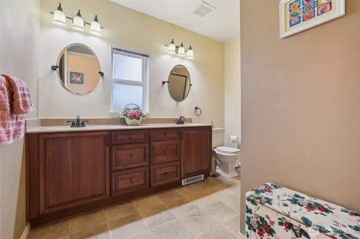3/4 bathroom with dual sinks and newer cabinetry