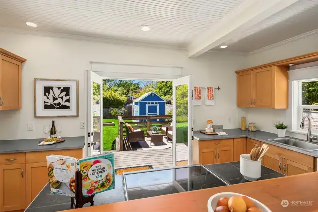 Kitchen French doors open up to sunny west-facing deck and backyard.