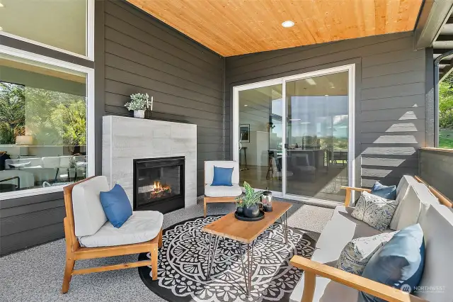 Covered deck off kitchen with fireplace.