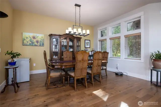 Dining area is tucked between the kitchen and entry and has views out to the forest.