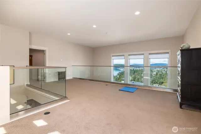 Bonus room at the landing at the top of the stairs provides another look at Burrows Bay. Large flex space has lots of options for a quiet room, den or what have you.