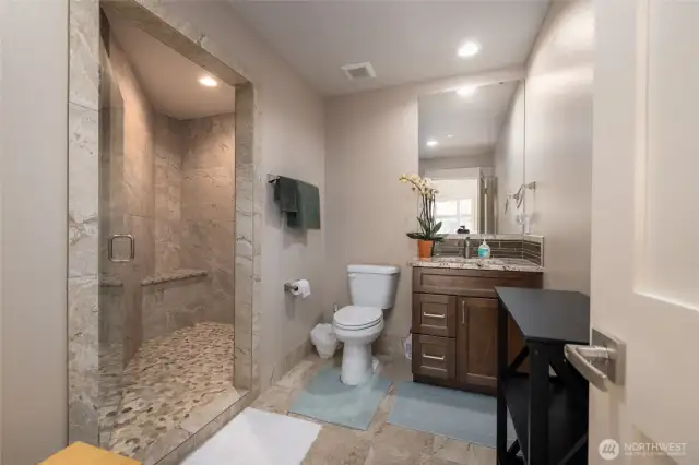 Upstairs bath has stone tile and granite countertops.