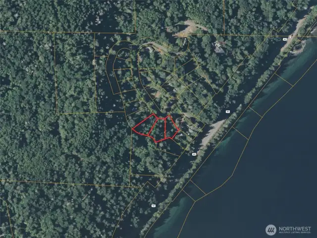 Approximate boundaries in red. Subject property is the middle lot. Neighboring lots for sale.