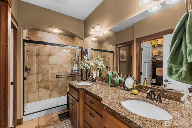 Tiled walk-in shower w/ dual sink vanities in primary bathroom