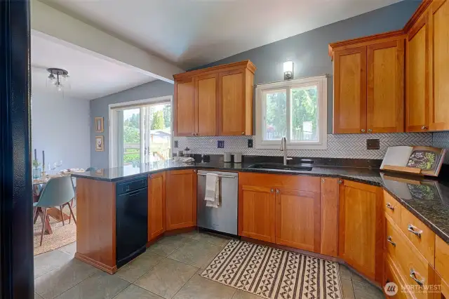 Large kitchen space with granite countertops and tons of cabinet space.