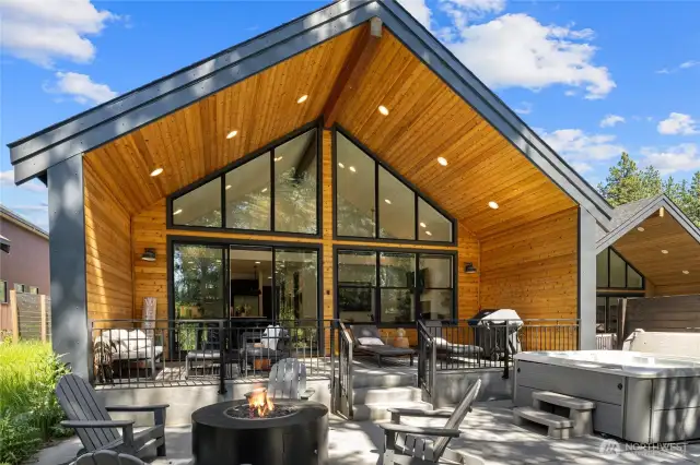 Back of home with firepit, covered patio, and hot tub