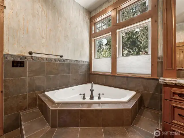 Tucked beneath large view windows with top-down privacy shades, the deep jetted soaking tub is surrounded by tile and finished with designer hardware. The perfect place to relax after a day on the trails or the golf course.