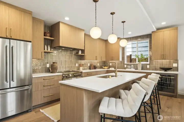 Showstopping Kitchen with 36" Bertazzoni range, Bellmont Cabinetry with soft close, slab quartz counters, designer lighting and hardware, wine fridge, & walk-in pantry.