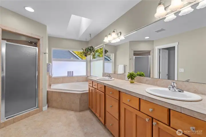 5-piece primary bathroom features a spacious shower and soaking tub.  The skylight floods the space with natural light.