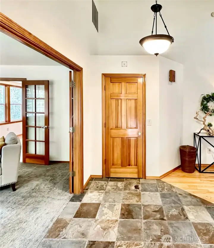 Vaulted foyer with easy-care slate floor, guest closet and easy access to the living room, hall to family room and stairwell to the lower level.