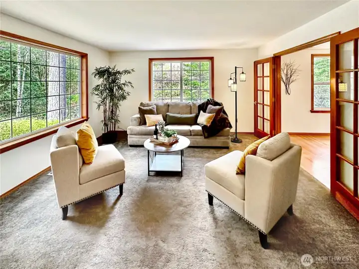 Lovely living room with large windows for natural light and two sets of French doors.