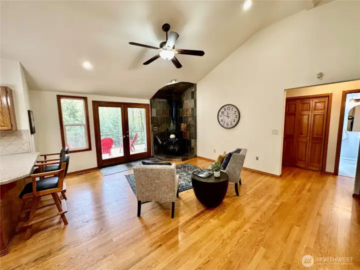 Cozy, vaulted family room with wood floors, wood burning free standing wood stove with slate surround and French door access to the rear sun deck.
