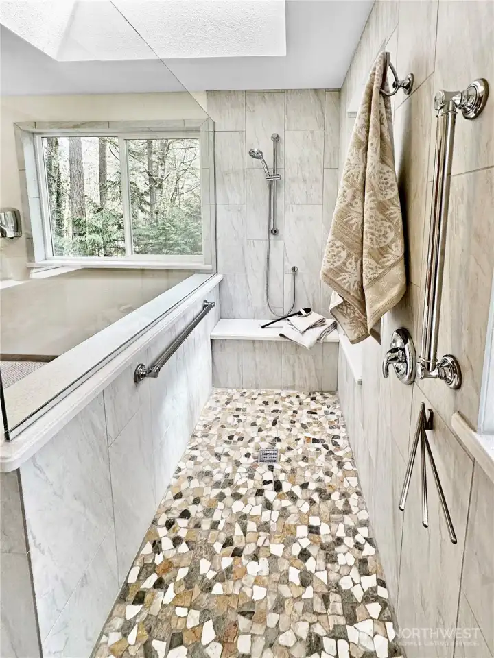 Close-up view of the primary shower with skylight above for natural light.