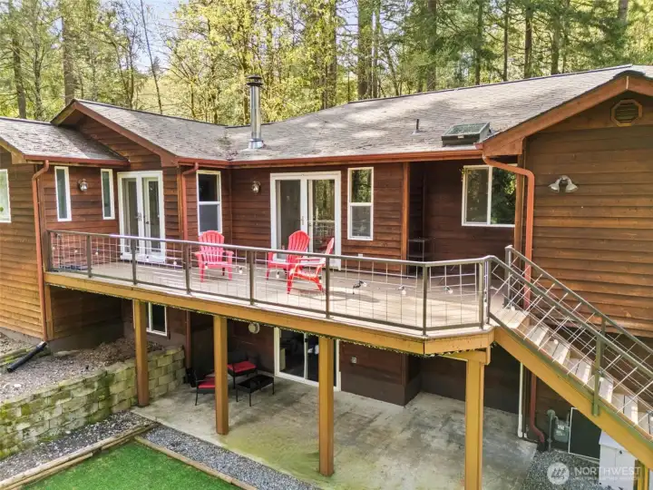 Rear view of the home showing the main floor composite sun deck and lower level covered patio.