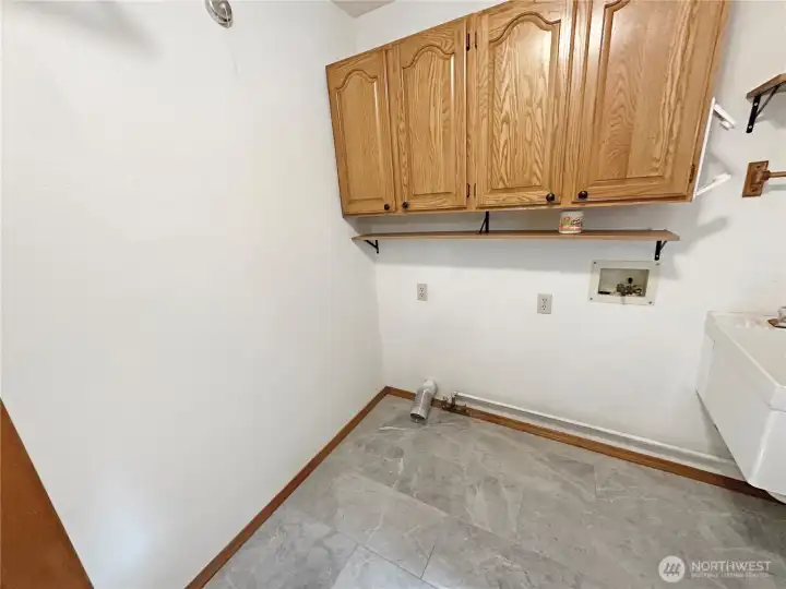 Main floor laundry room with utility sink and door to the rear deck. Main floor laundry room with utility sink and door to the rear deck.
