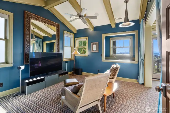 The primary suite showcases beautiful beamed and vaulted ceilings that enhance its sense of space and character. A charming sitting area provides the perfect nook for curling up with a book or enjoying a relaxing movie in a private, comfortable setting.