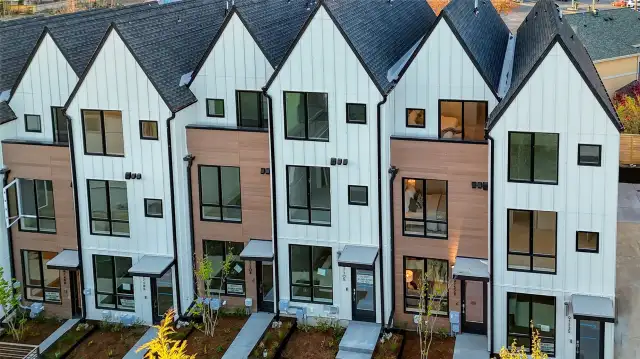 Say hello to curb appeal! Crisp white exteriors with earthy wood tones and geometric peaks create a calm yet bold first impression.