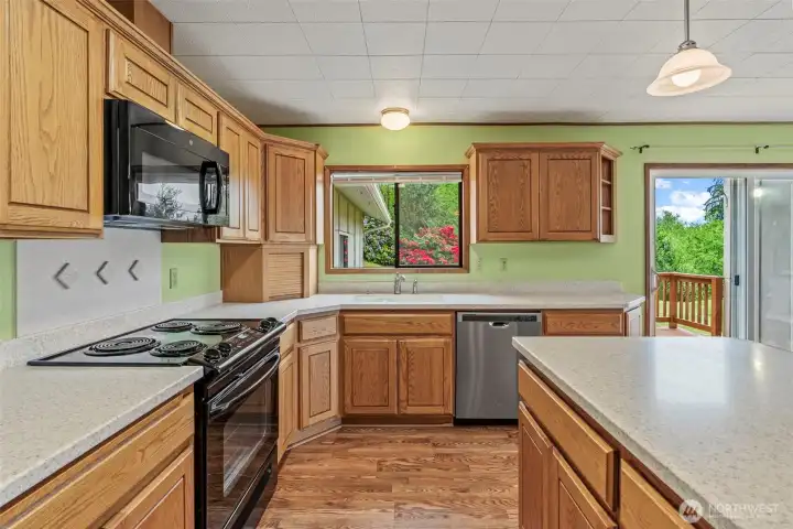 Large kitchen, oak cabinets, Corian countertops, laminate floors and newer appliances.