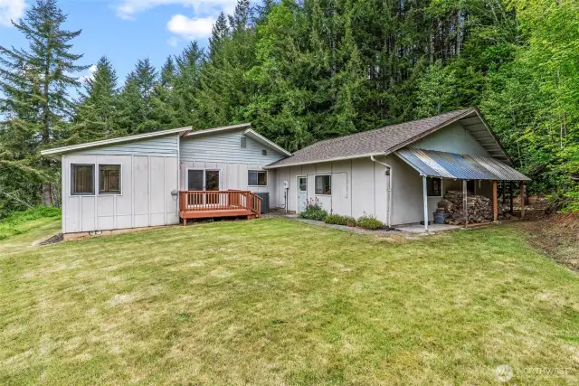 East side of home, additional deck w/slider to dining area; garage entrance, covered wood storage.