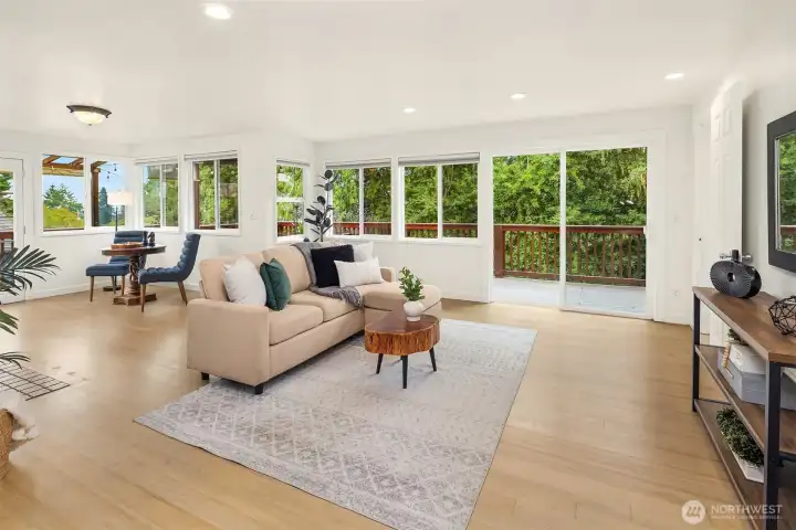 Inviting, sunlit family room with a wall of windows overlooking the deck, which runs the full width of the home.