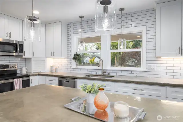 The kitchen in the heart of the home.  Enjoy newer stainless appliances (microwave, range/oven, dishwasher, and fridge/freezer), tons of storage, and a view to the front patio.