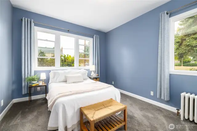 The primary suite offers plenty of space for a king-sized bed (queen bed shown), has windows on two walls, and a private ensuite bath and walk-in-closet.