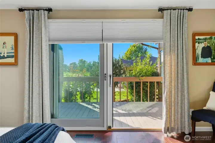 Primary bedroom with view out the door to the private deck