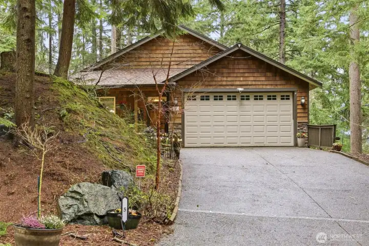 Two car garage with gently sloped drive and lots of parking.