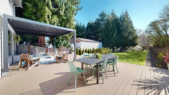 Expansive backyard designed for both entertaining and relaxation. A 600+ sq ft deck features a built-in hot tub, louvered pergola, and fire pit, while the lush yard offers garden beds, fruit trees, and a serene garden dome - your perfect cozy rainy-day retreat.
