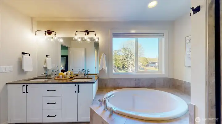 Primary Suite bath with double vanity and soaking tub.