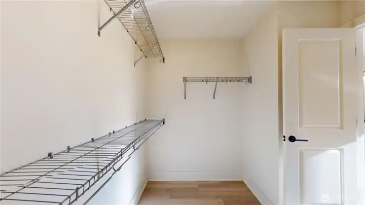 Primary Suite walk-in closet is L-shaped.  As you come through the door and look left, there is another long rod not shown in photograph.