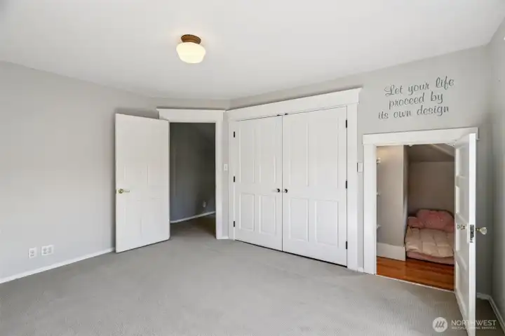 West facing bed showing closed closet doors and hide-away nook
