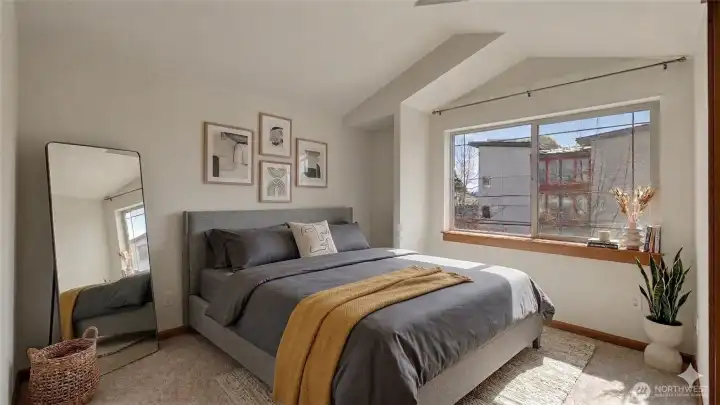 Primary suite with vaulted ceilings, walk-in closet and seating nook. Virtually staged