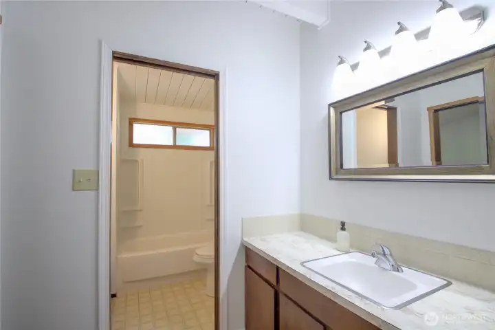 The vanity is separate from the shower/tub/toilet space.