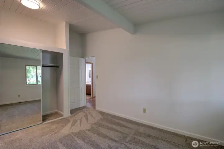 This is the second bedroom with a view of the closet and a view out the door of the bathroom.