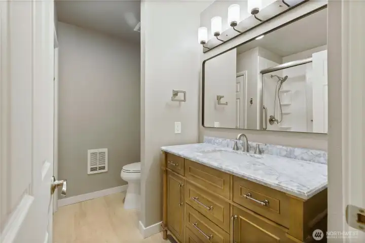 Primary bath with new vanity, sink lighting and mirror. Primary bath with new vanity, sink lighting and mirror.