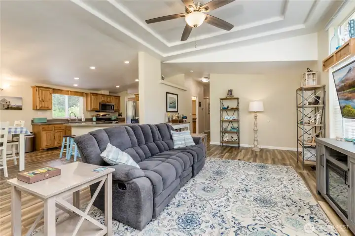 Living room with tray ceiling flows easily into the kitchen and dining areas. Living room with tray ceiling flows easily into the kitchen and dining areas.