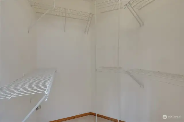 This walk in closet offers a plethora of storage space and hanging room!
