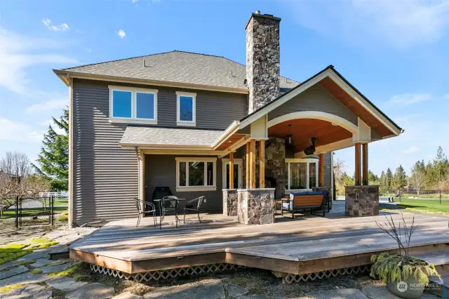 Back of house has covered and heated seating with huge gas fireplace.