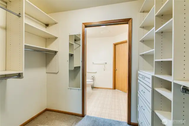 Huge walk in closet with closet organizers.