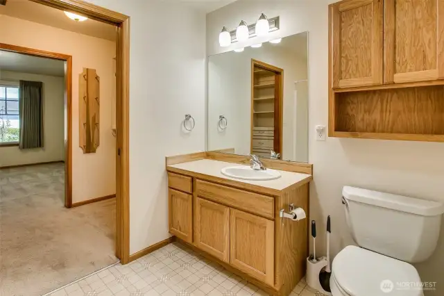 Primary bathroom with grab holds by the toilet and pocket doors.