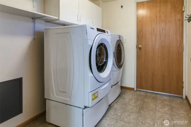 Front load washer and dryer set tucked between the garage and kitchen.