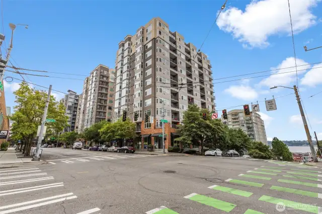 From the sidewalk, take in the full building façade and a glimpse of the nearby shoreline.