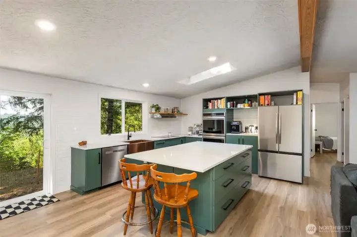 Fully renovated kitchen that's a baker's dream with custom cabinets, quartz countertops, stainless steel appliances including a double oven, and a gorgeous island.