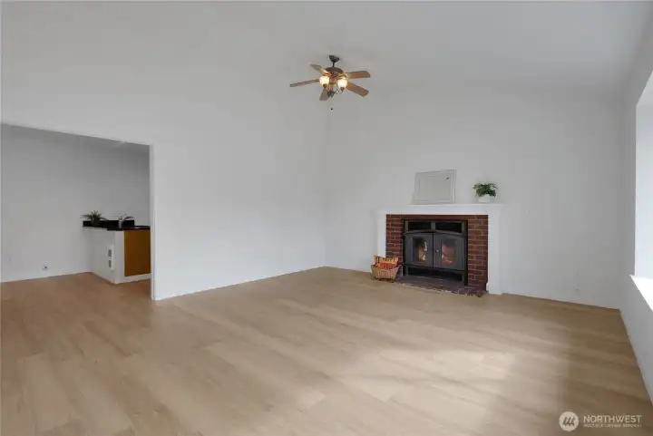Bright living room with cozy fireplace, new flooring & paint.