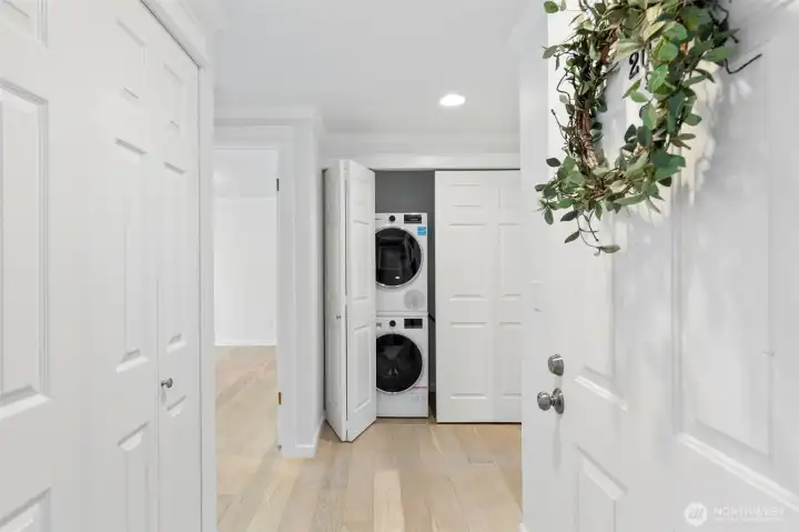 A spacious entryway features two hall closets for storage and full size stacked laundry.