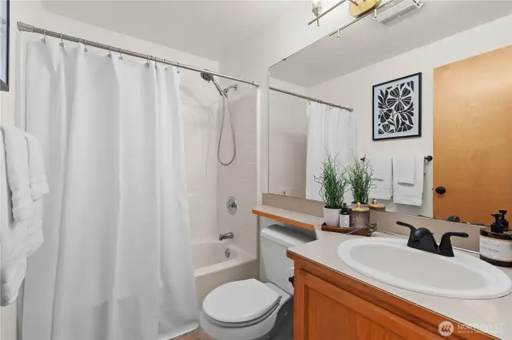 Hall bath with bathtub and shower!  New light fixtures and faucet.  Enjoy new floors in here too!