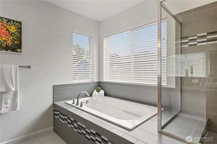 Huge ensuite 5-piece bathroom with builder upgraded tile countertops and tile flooring