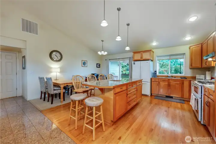 Vaulted ceiling, view of the kitchen and dining room